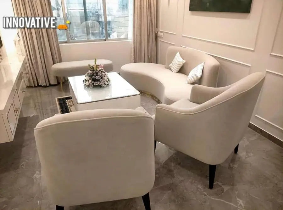 Cream velvet sofa and two lounge chairs around a white coffee table