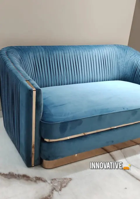 Blue velvet pleated sofa with a brass base trim