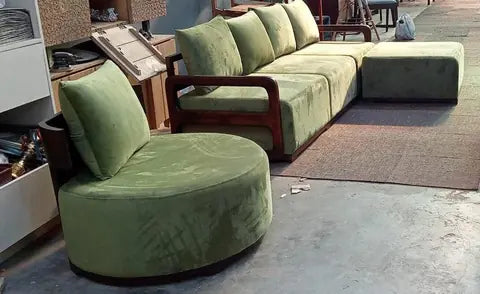Green velvet sofa and round chair with dark wooden frames