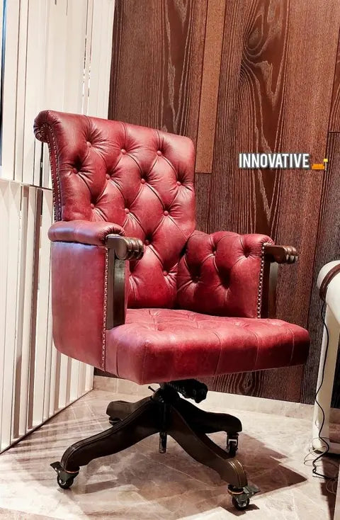 Red tufted leather boss chair on a dark wooden swivel base