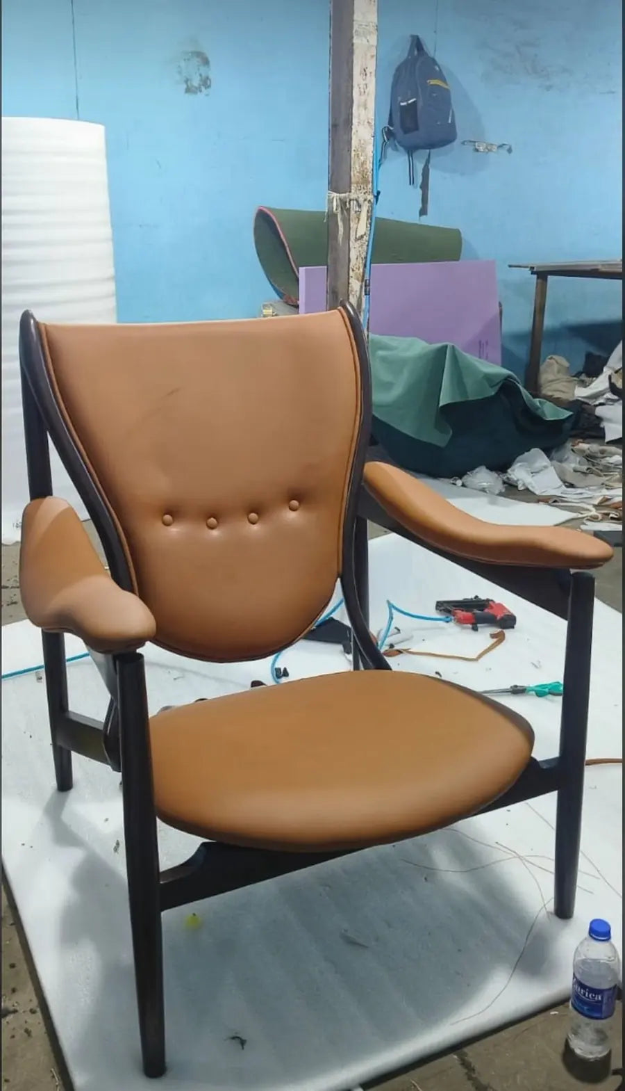 Tan leather chair with a dark wooden frame in the workshop