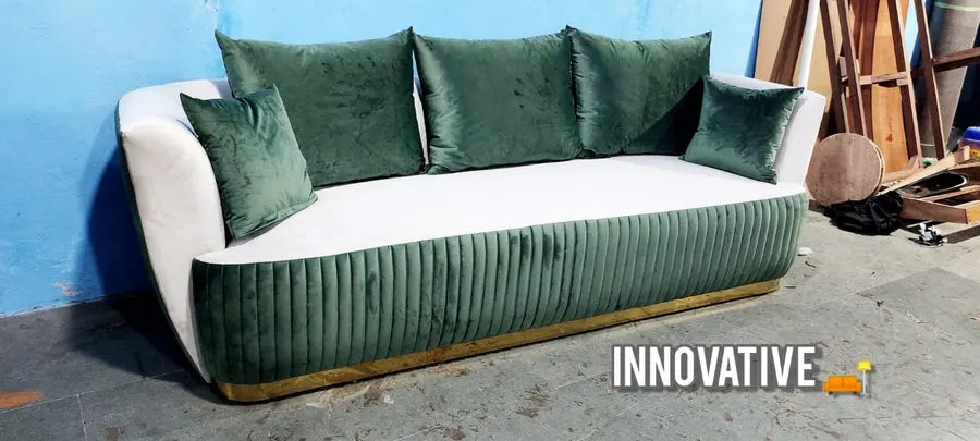 Green pleated three-seater sofa with velvet cushions