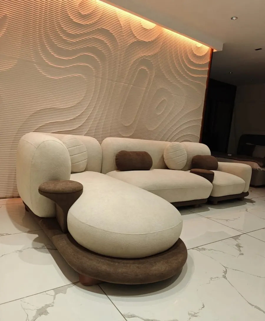 Cream boucle sectional sofa with brown cushions and a curved chaise